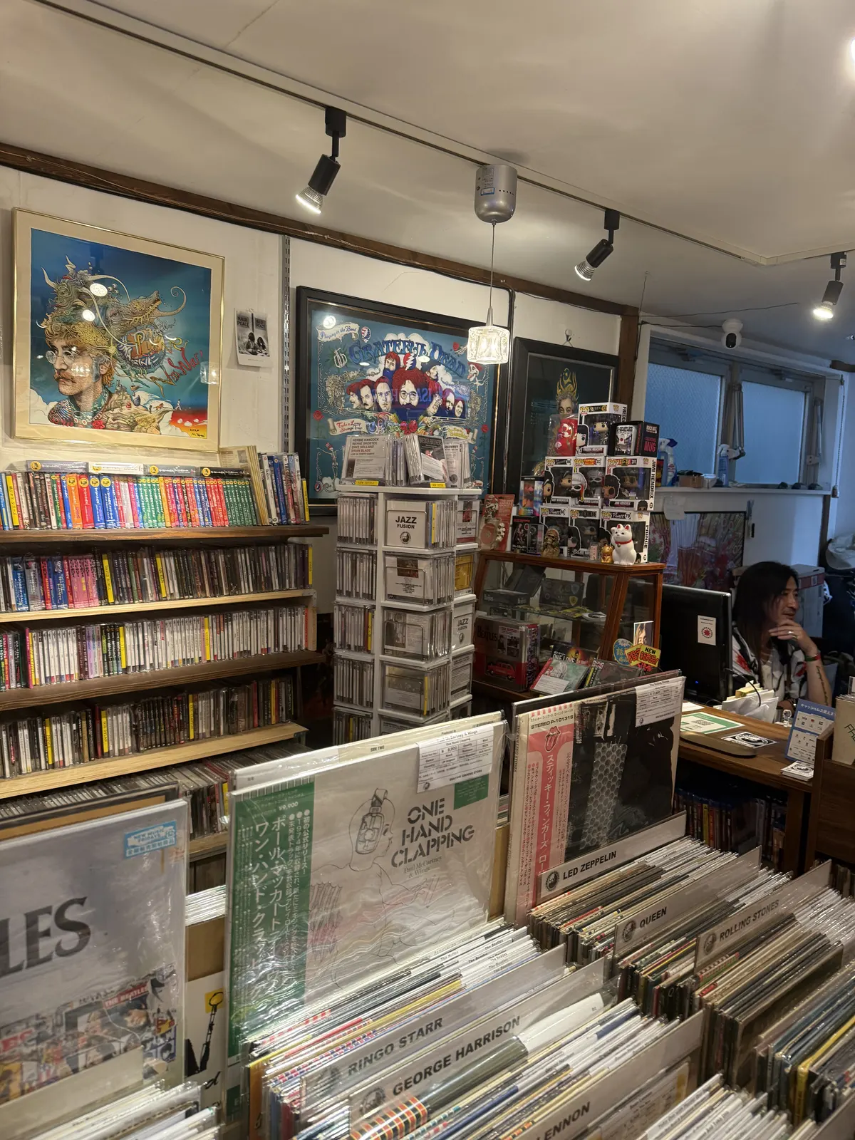 スタッフの気配とレコード棚が見える店内